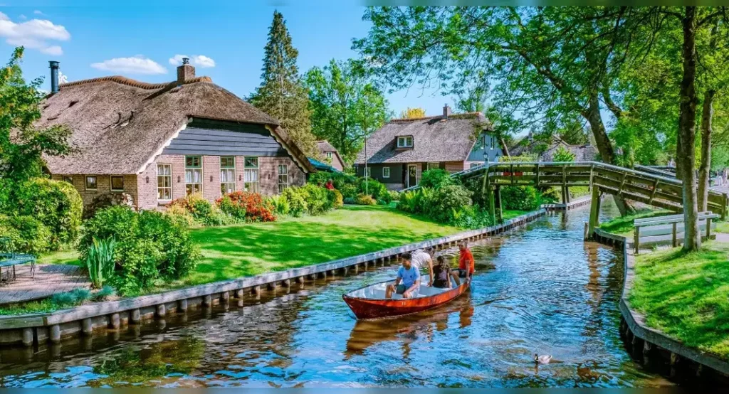 Giethoorn, Netherlands – A quaint village with winding canals and orange autumn foliage reflected in the water