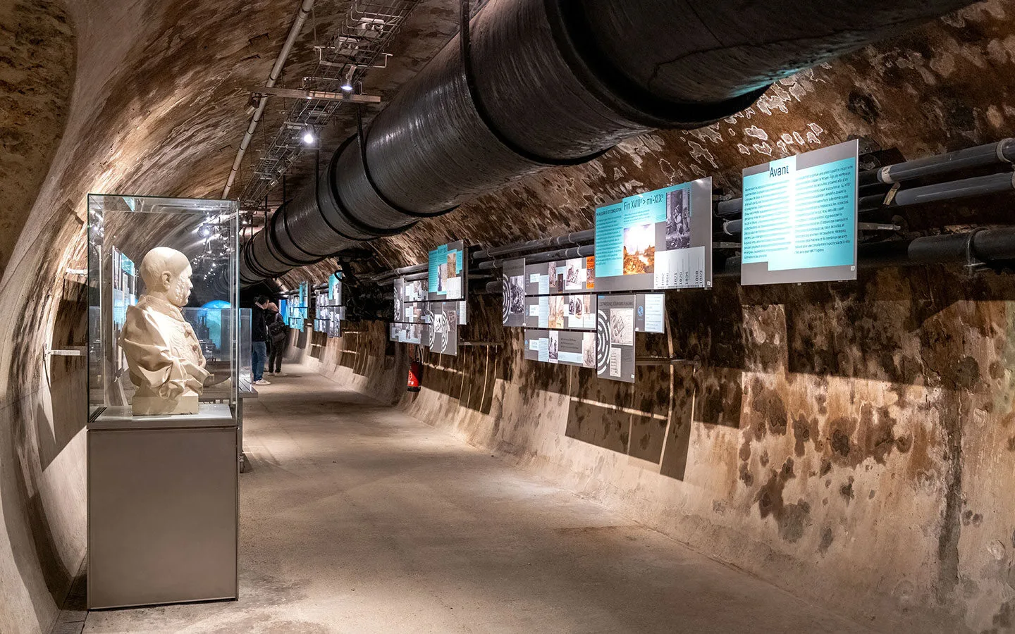 Visitors walking through the dimly lit tunnels of the Paris Sewer Museum