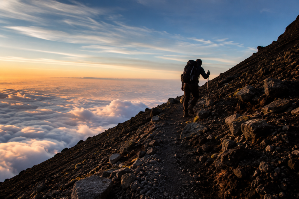 Hiker ascending the volcanic trail on Mount Pico